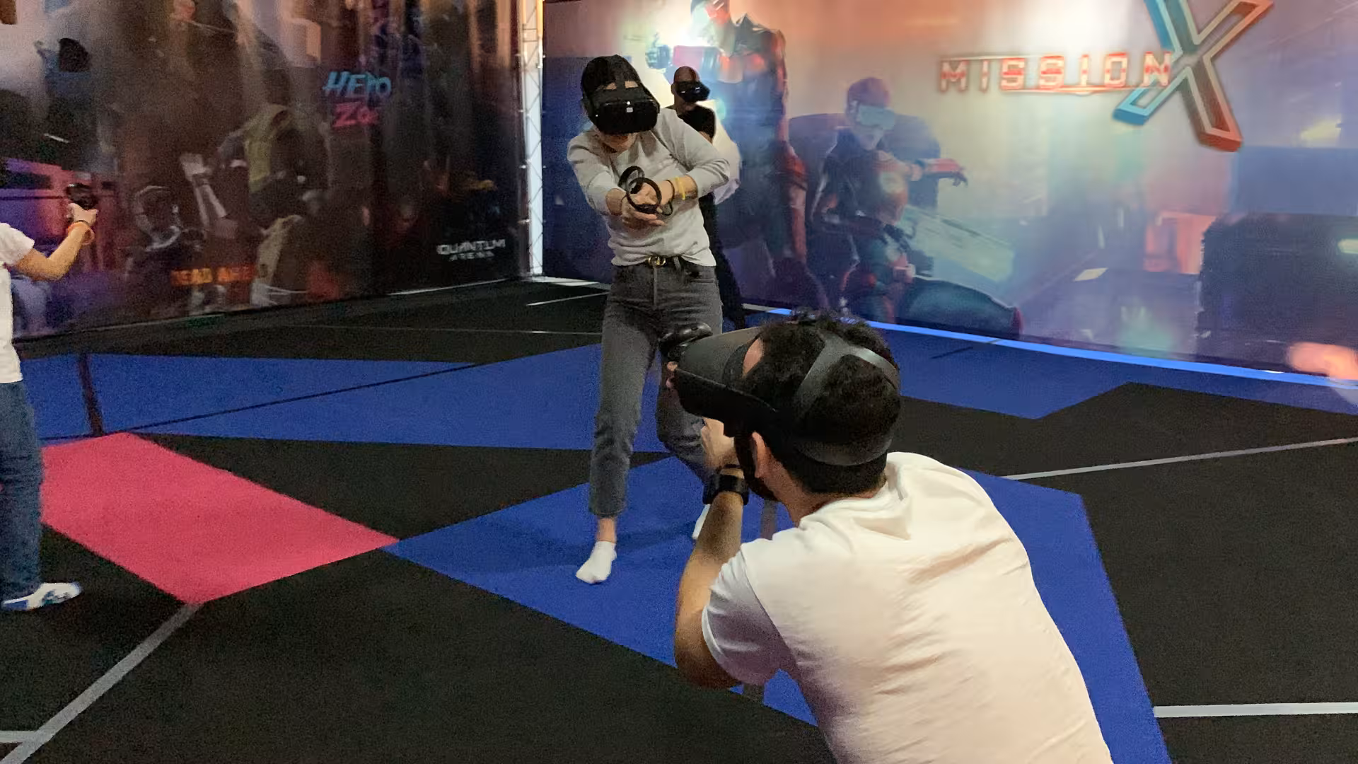 Players in Laser Game VR 35 VR arena aiming controllers in a team shooter match on a large free-roam space