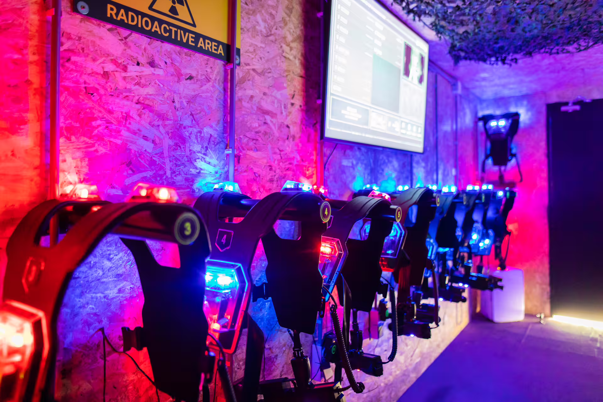 Laser tag gear lined up with glowing vests and blasters at an Amsterdam indoor arena, ready for play