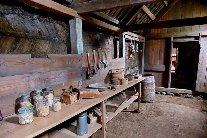 Historic rustic kitchen interior at Laufas museum in North Iceland with wooden shelves and antique tools