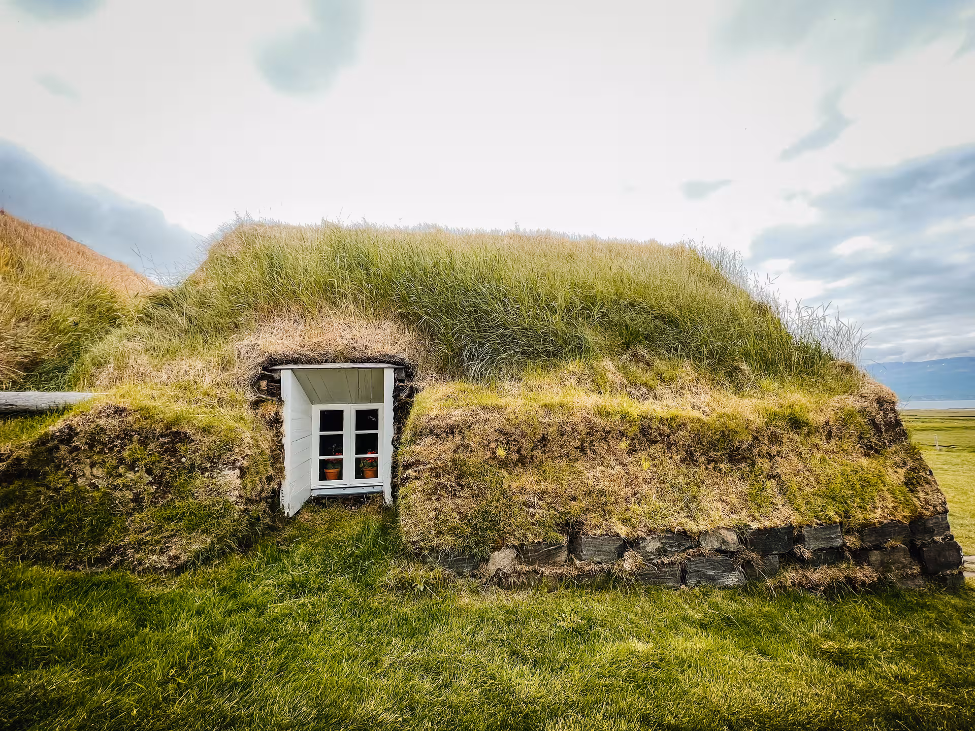 Grass-covered turf house entrance at Laufás Museum, a stop on the private Goðafoss and Forest Lagoon tour
