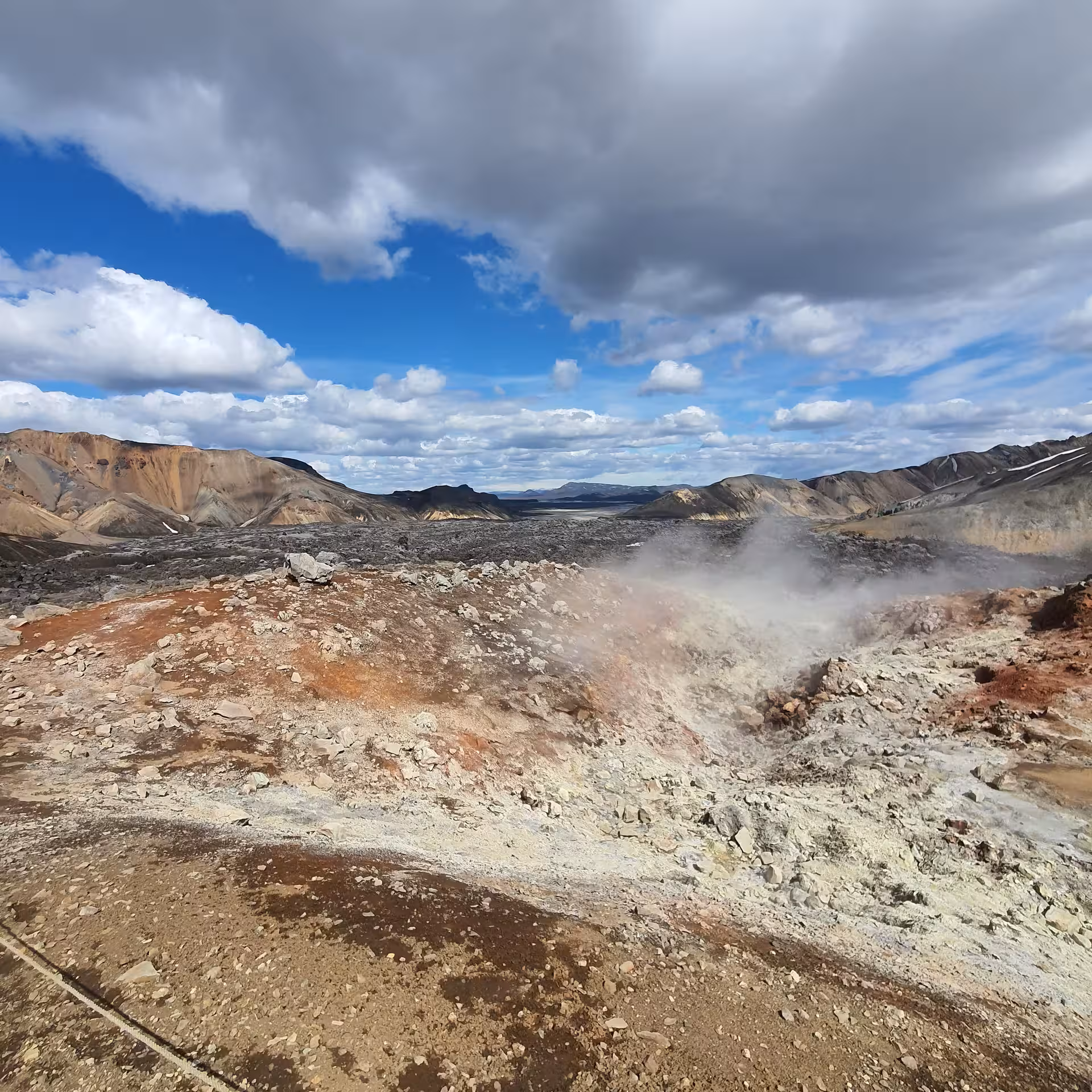Geothermal steam vents and colorful rhyolite mountains along the Laugavegur Trek in Iceland's highlands