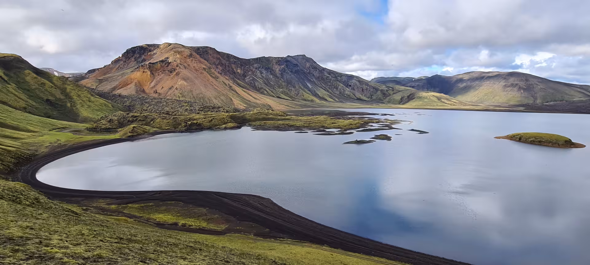 Calm glacial lake reflecting mountains on the Laugavegur Trek in Iceland's highlands