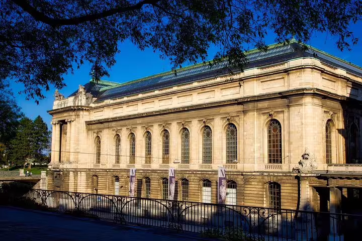 Neoclassical stone building with arched windows and green roof in Lausanne, Switzerland on a sunny day