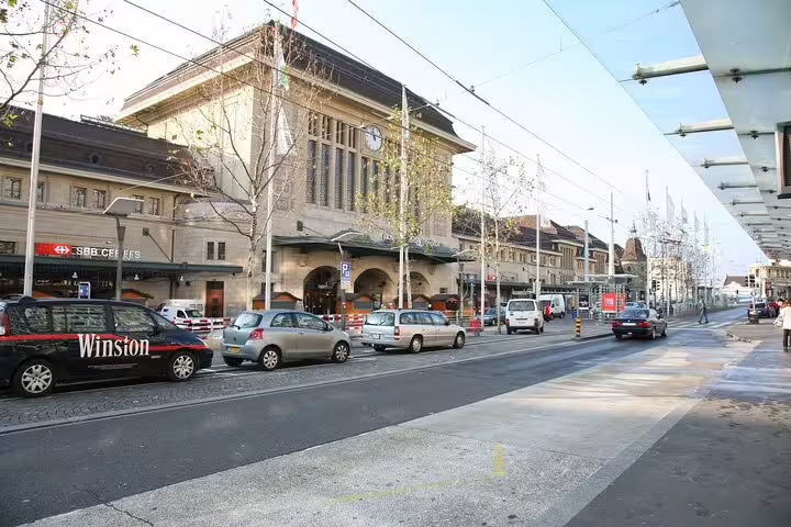 Lausanne train station street view with cars and historic building facade
