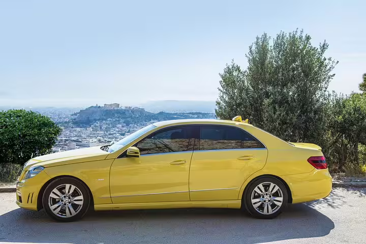 Private sedan transfer from Lavrio port or hotels to Athens airport, parked with panoramic Athens city view