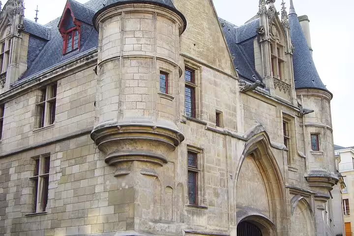 Historic Gothic stone building with turrets and arched gateway in Le Marais district Paris