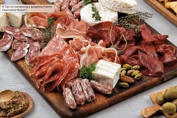 French charcuterie board with cured meats, salami, soft cheeses, pistachios, and almonds on wooden board