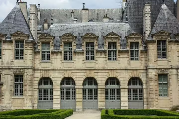 Historic Hôtel de Sully mansion facade in Le Marais district, Paris, with manicured hedges