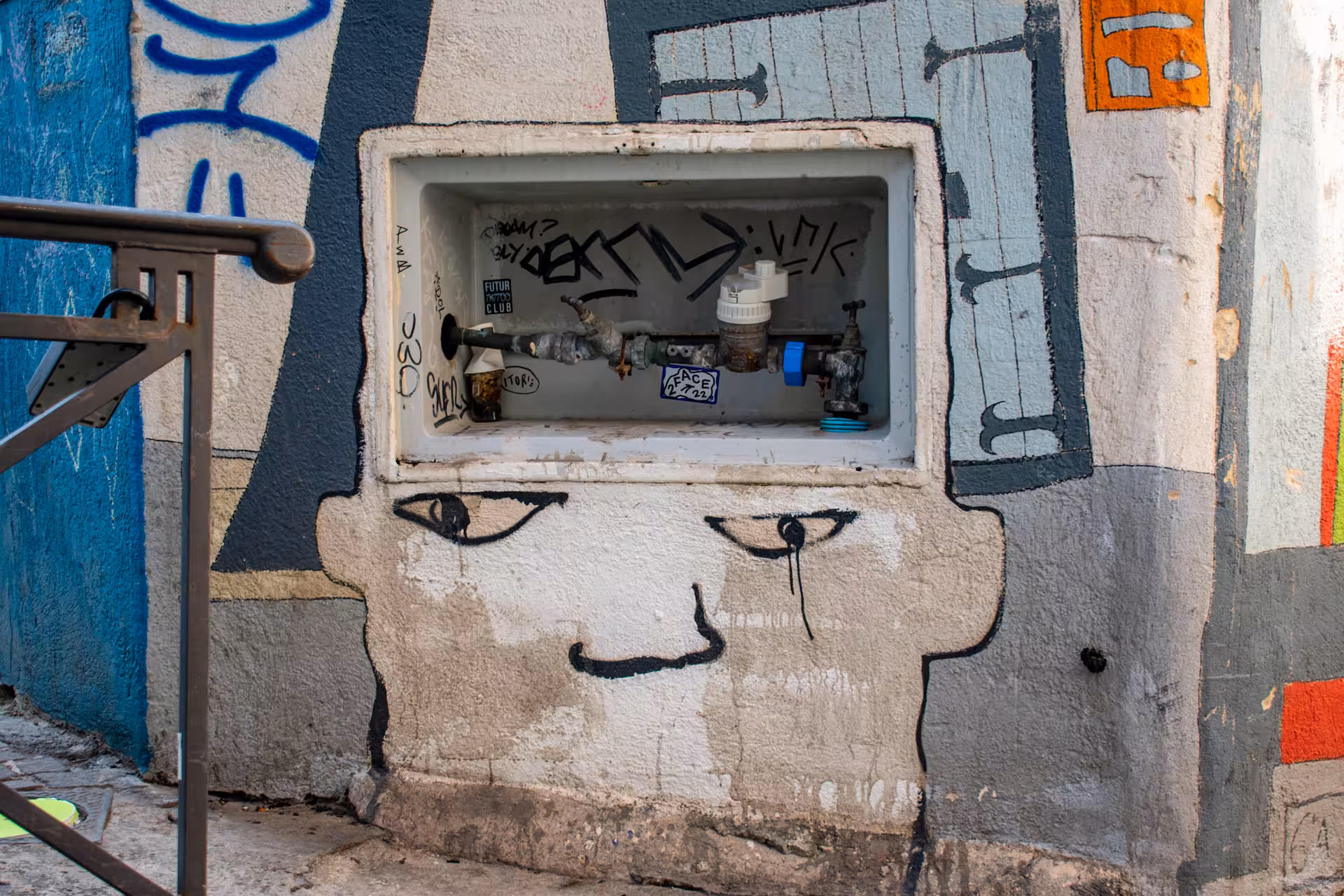 Graffiti mural face with water meter in Le Panier, Marseille, featured on the oldest neighborhood walking tour