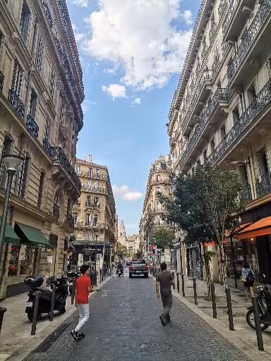 Cobbled Marseille street near Le Panier, Haussmann buildings and cafés on guided walking tour route