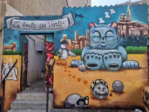 Colorful Le Panier Marseille street art mural by a doorway, a highlight stop on the oldest neighborhood walking tour