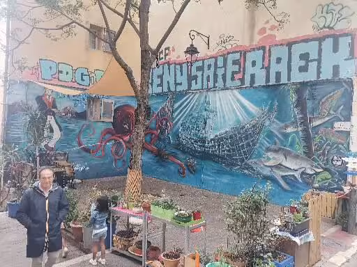 Le Panier Marseille walking tour stop by colorful street art mural with ocean scene in the oldest neighborhood