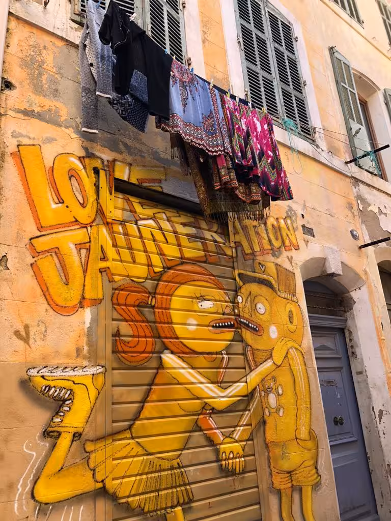 Colorful Le Panier street art mural in Marseille with laundry above, highlight of the guided food tour walking route