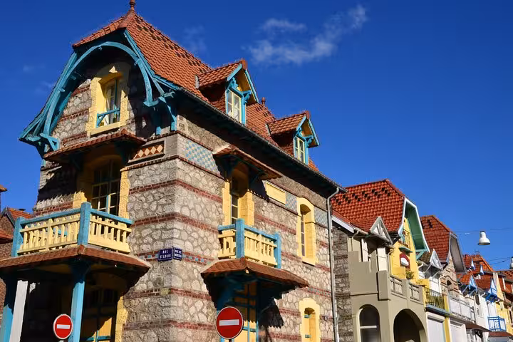 Colorful Belle Époque stone villa with teal balconies and red tiled roof in Le Touquet, France