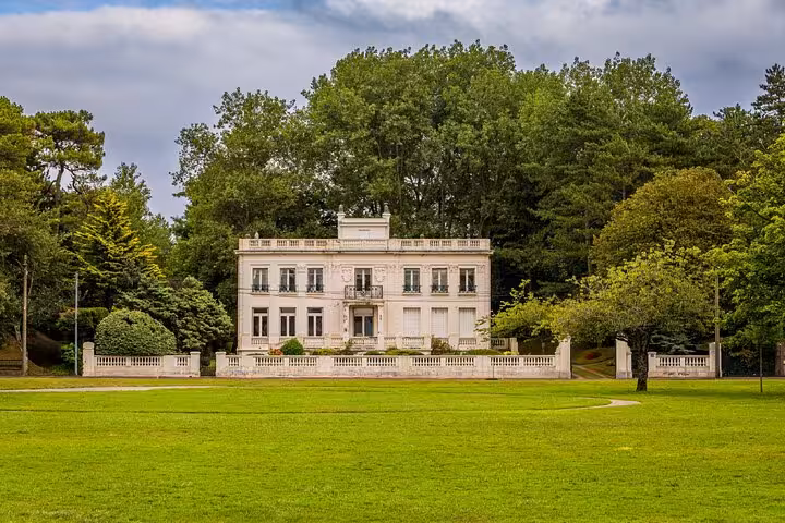 Elegant white French villa with manicured lawns and lush trees in Le Touquet, France
