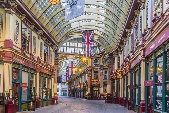 Victorian covered arcade of Leadenhall Market with Union Jack flags and ornate painted ironwork, London