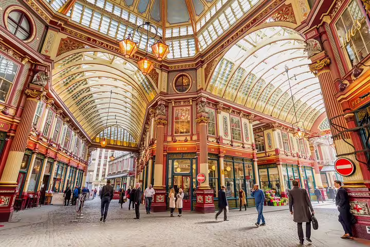 Visitors stroll under the ornate glass roof of Leadenhall Market, an iconic London spot near the Tower of London tour.