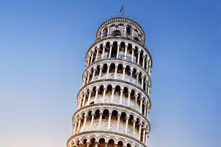 Iconic Leaning Tower of Pisa against a clear blue sky, a highlight of the Discover Lucca and Pisa tour.