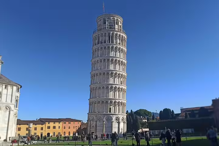 Leaning Tower of Pisa against clear blue sky with tourists in Piazza dei Miracoli on private Tuscany wine tour