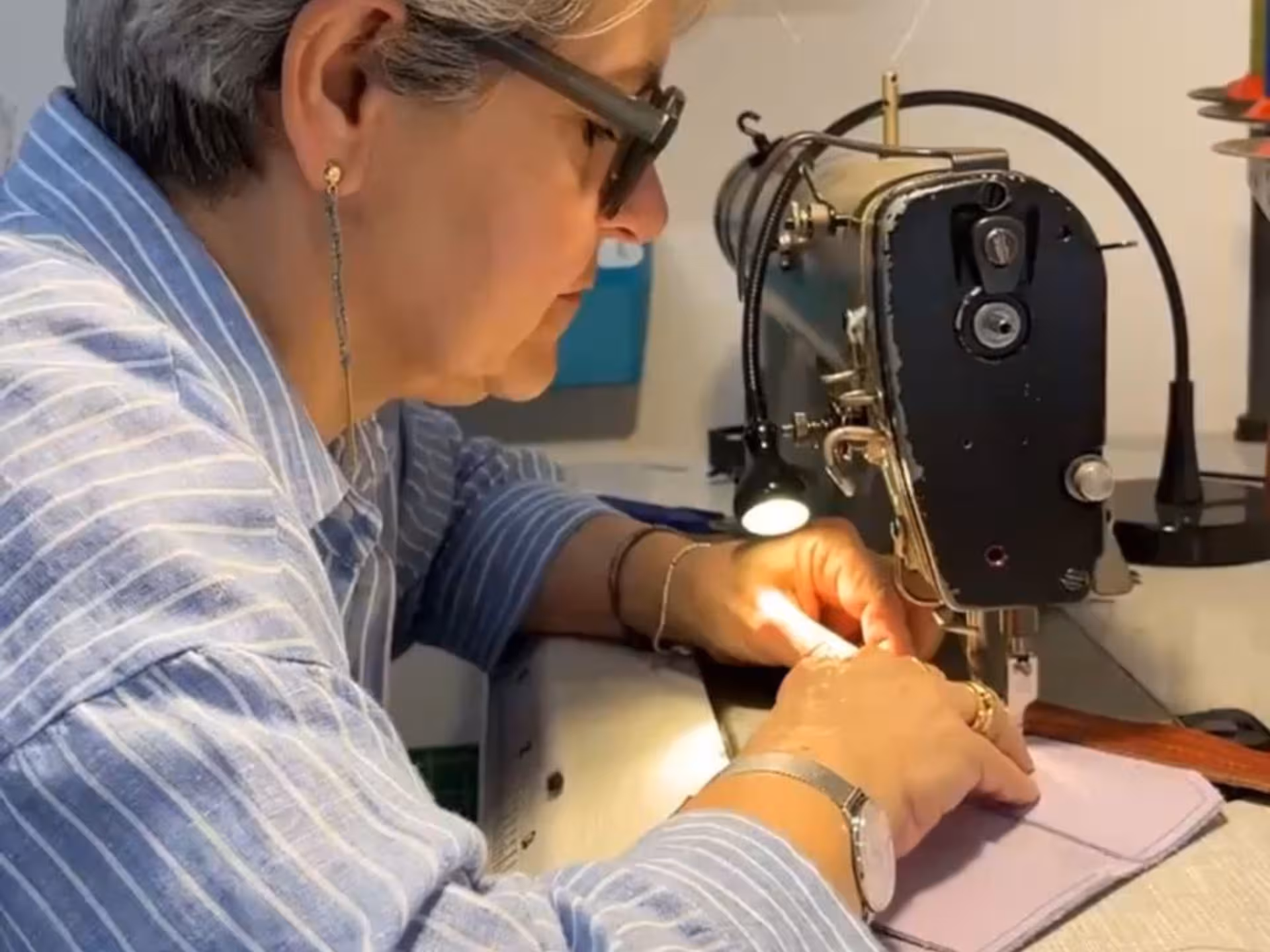 Participant sewing a leather wallet at a hands-on crafting workshop in Verona, guided by expert artisans.