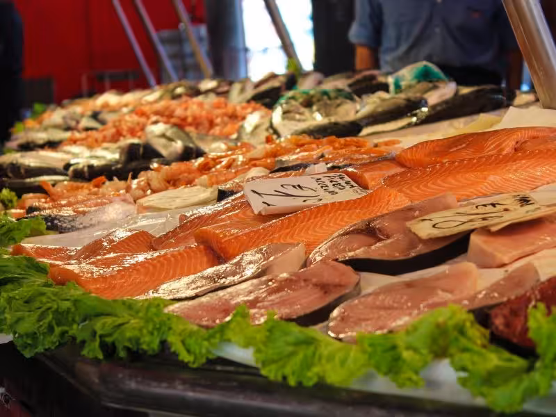 Colorful fish market stall in the Leeward Islands showcasing fresh salmon, tuna and seafood for authentic Caribbean tours