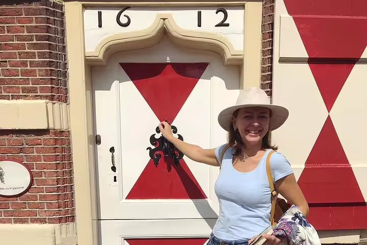 Guide on half-day private Leiden tour at historic 1612 doorway with red-and-white shutters in the city center