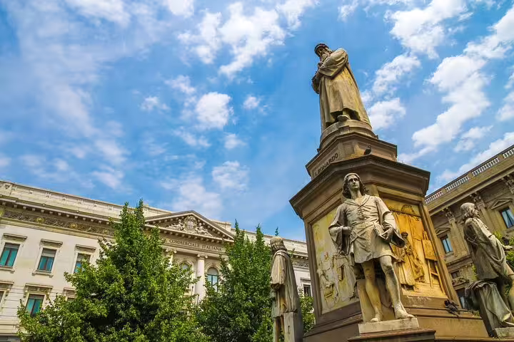 Leonardo da Vinci monument statue in Piazza della Scala, Milan, with neoclassical building in background