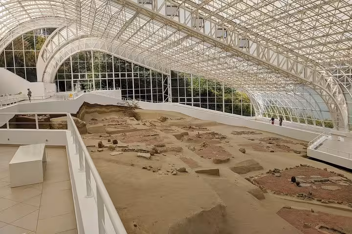 Interior view of Lepenski Vir archaeological site along the Danube, showcasing ancient settlement remains under a glass canopy.