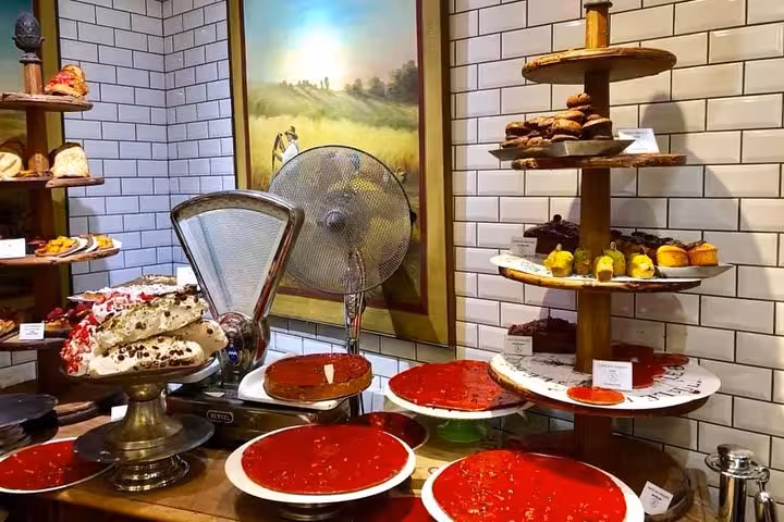 Assortment of desserts and pastries elegantly arranged in a patisserie at Les Halles Paul Bocuse, featuring French delicacies.