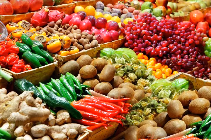 Vibrant display of fresh fruits and vegetables at Les Halles Paul Bocuse, highlighting diverse produce on market tour.