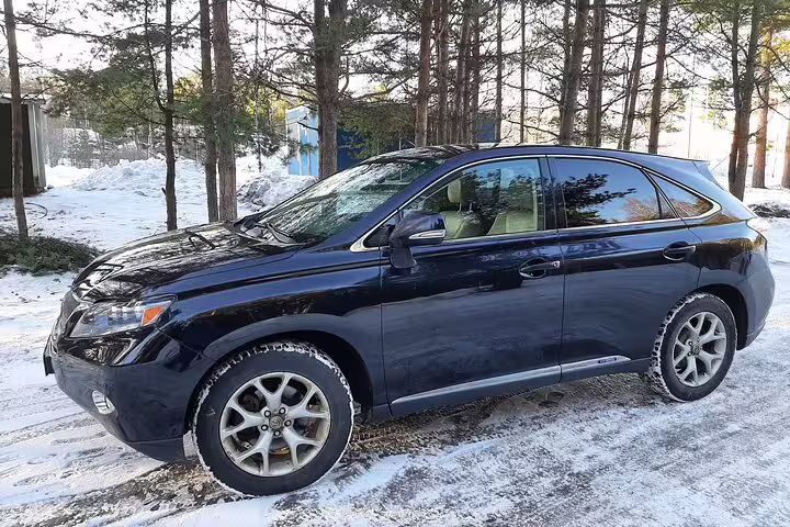 Dark blue Lexus SUV private transfer parked on snowy ground for Oslo Airport to Trysil Ski Resort transport