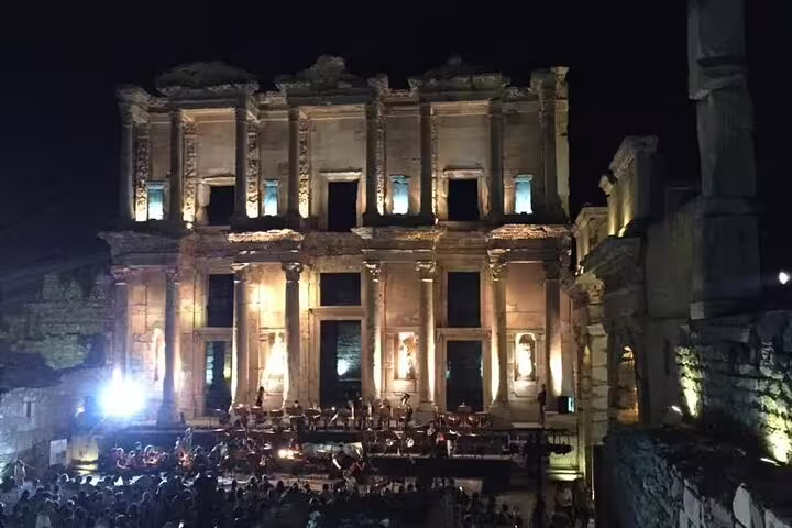 Night view of the Library of Celsus in Ephesus during a private tour with illuminated ruins and crowd