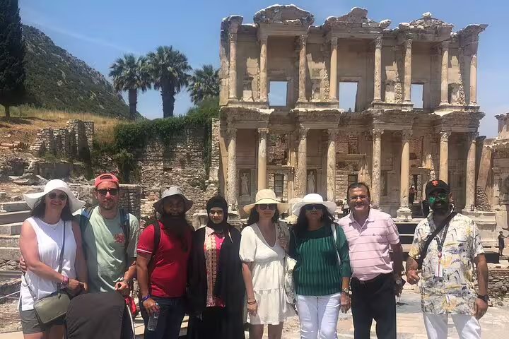 Visitors pose in front of the iconic Library of Celsus during a private Ephesus tour from Kusadasi Port, under sunny skies.