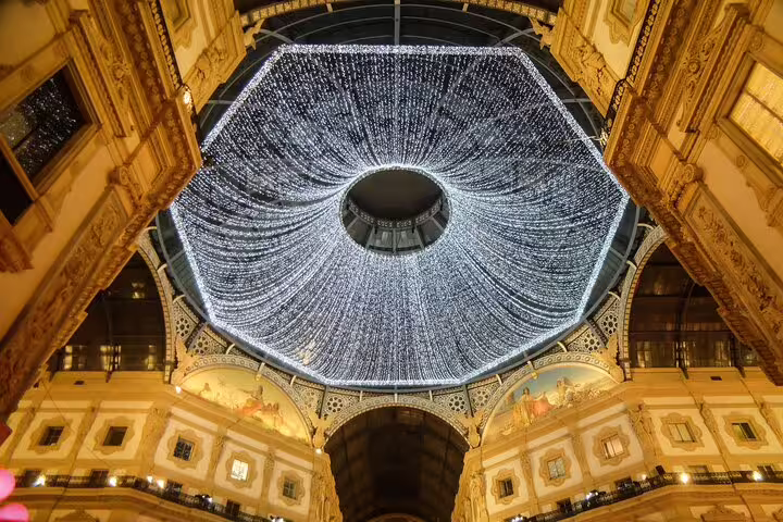 Stunning illuminated ceiling inside Milan's Galleria Vittorio Emanuele II, showcasing luxury shopping ambiance.