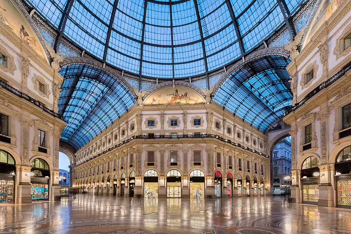 Elegant interior of Galleria Vittorio Emanuele II in Milan, featuring iconic glass dome and upscale boutiques.