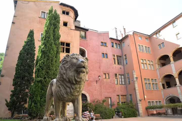Stone lion statue in a colorful Renaissance courtyard in Lyon Old Town