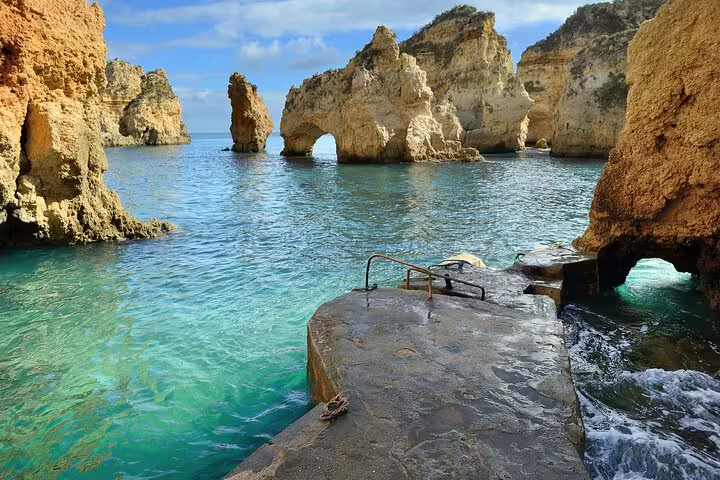 Scenic coastal rock formations and clear turquoise waters near Lisboa, highlighting natural beauty on the Lisboa-Barcelona tour.