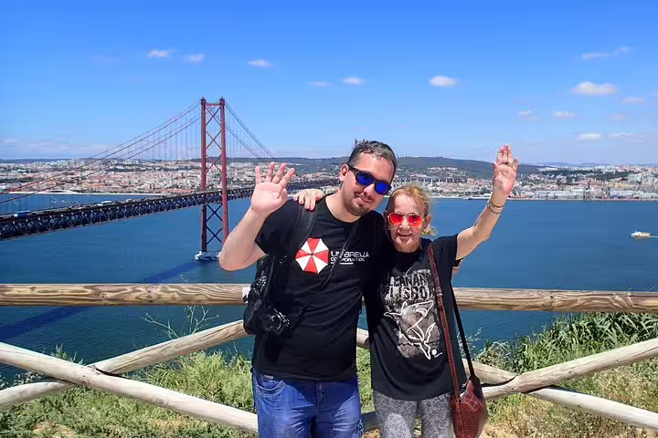Couple enjoying scenic views of Lisbon's iconic 25 de Abril Bridge during a private South Sights & Wine tour.