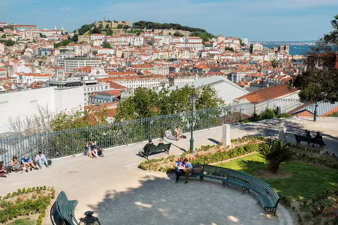 Enjoy panoramic views of Lisbon's historic Alfama district and vibrant cityscape from a scenic lookout on a small group tour.