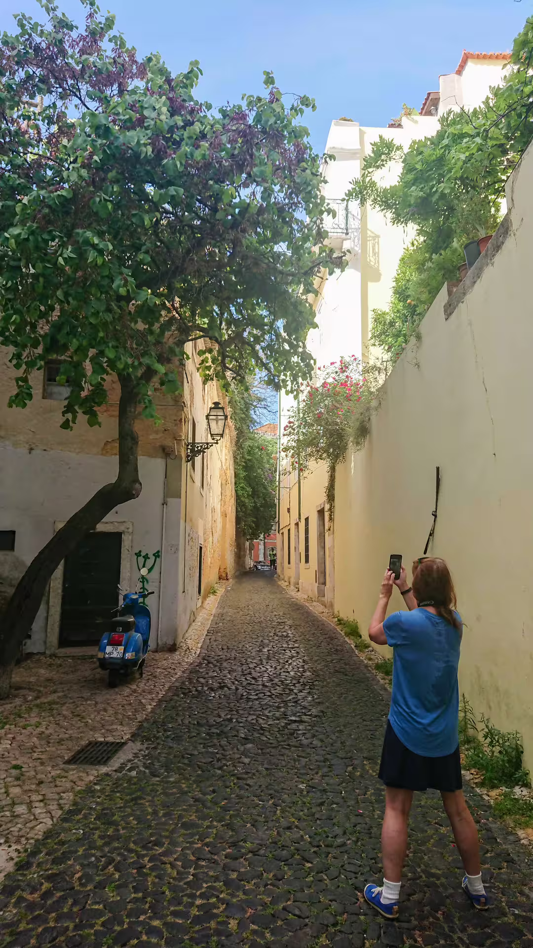 A visitor captures the charm of Alfama's narrow cobblestone streets and vibrant scenery during a Lisbon photography tour.