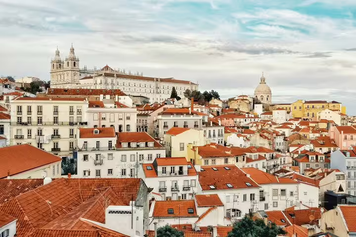 Scenic view of Lisbon's historic Alfama district with iconic red rooftops and notable landmarks, ideal for exploration.