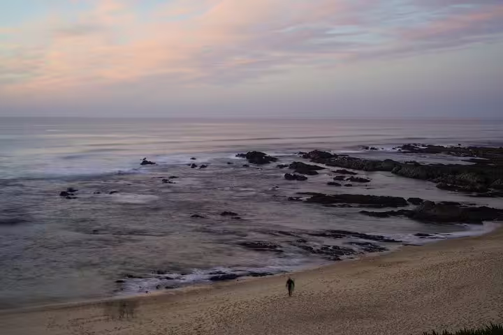 Coastal view of a serene beach at sunset along the Lisbon to Algarve route, highlighting Portugal's stunning seascapes and travel allure.