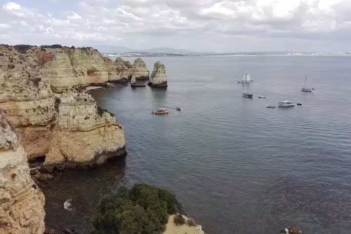 Scenic Algarve coastal tour from Lisbon showcasing stunning cliffs, boats, and ocean views for a memorable travel experience.