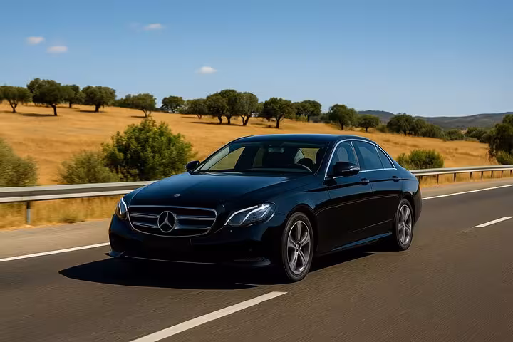 Luxury Mercedes sedan traveling on a sunny Lisbon to Algarve highway, offering a premium private transfer experience.