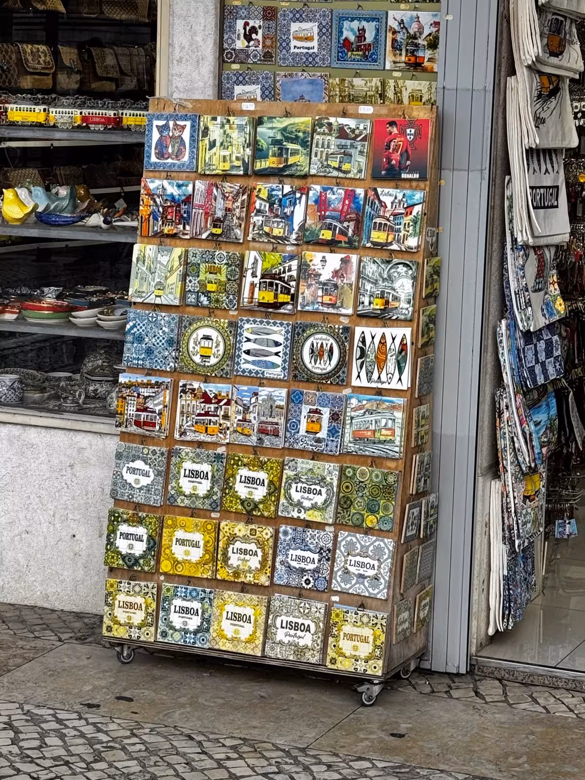 Lisbon souvenir tile stand with azulejo magnets and tram art, ideal stop on an audio guided City Quest hunt