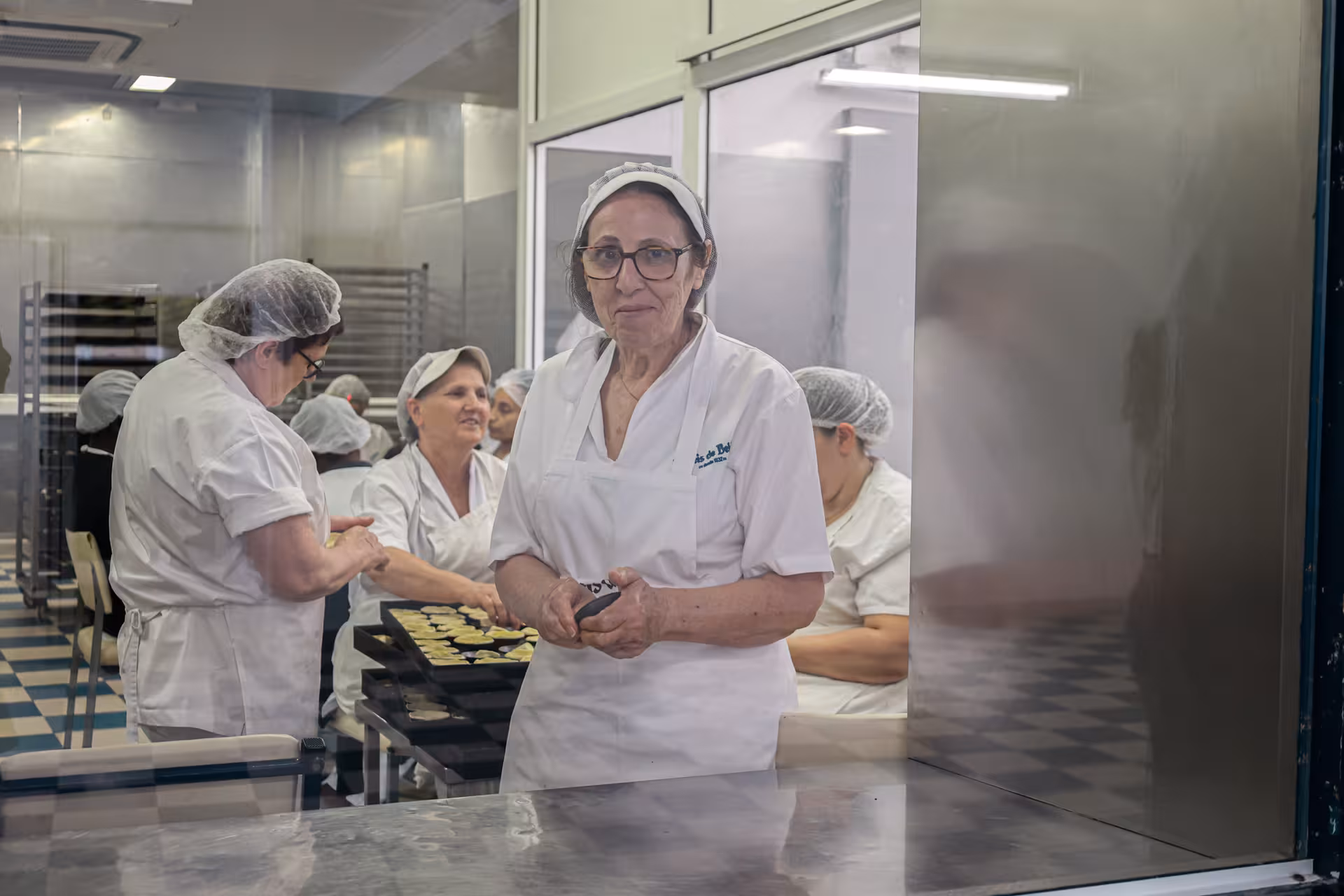 Artisan bakers crafting pastel de nata at a traditional kitchen in Lisbon, a highlight of the Belém sites tour.