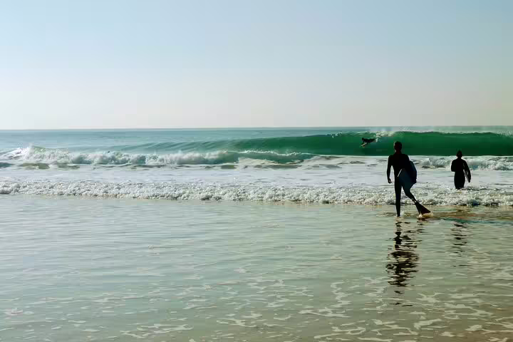 People enjoy a thrilling bodyboarding session on the scenic Lisbon coast, capturing the excitement of ocean adventure.