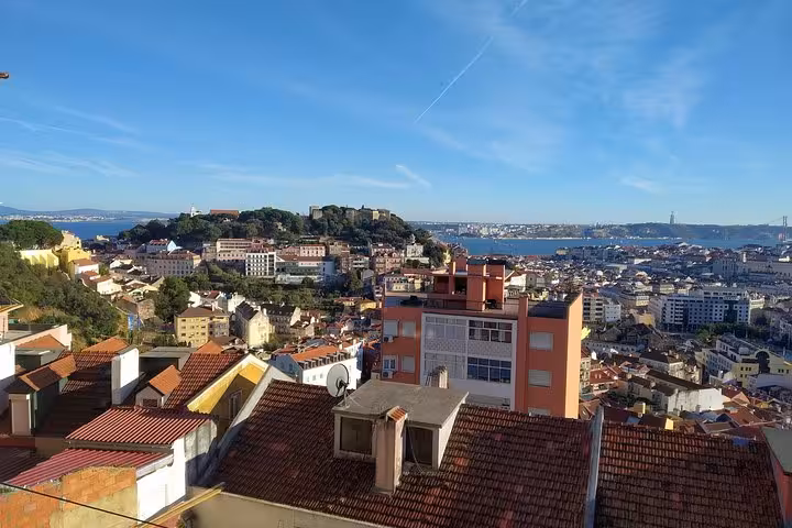 Enjoy stunning cityscape views of Lisbon from a rooftop, featuring the iconic São Jorge Castle.
