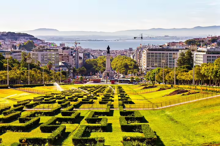 Panoramic view of Lisbon's Eduardo VII Park with cityscape, perfect for private full-day tour in premium vehicle with custom stops.