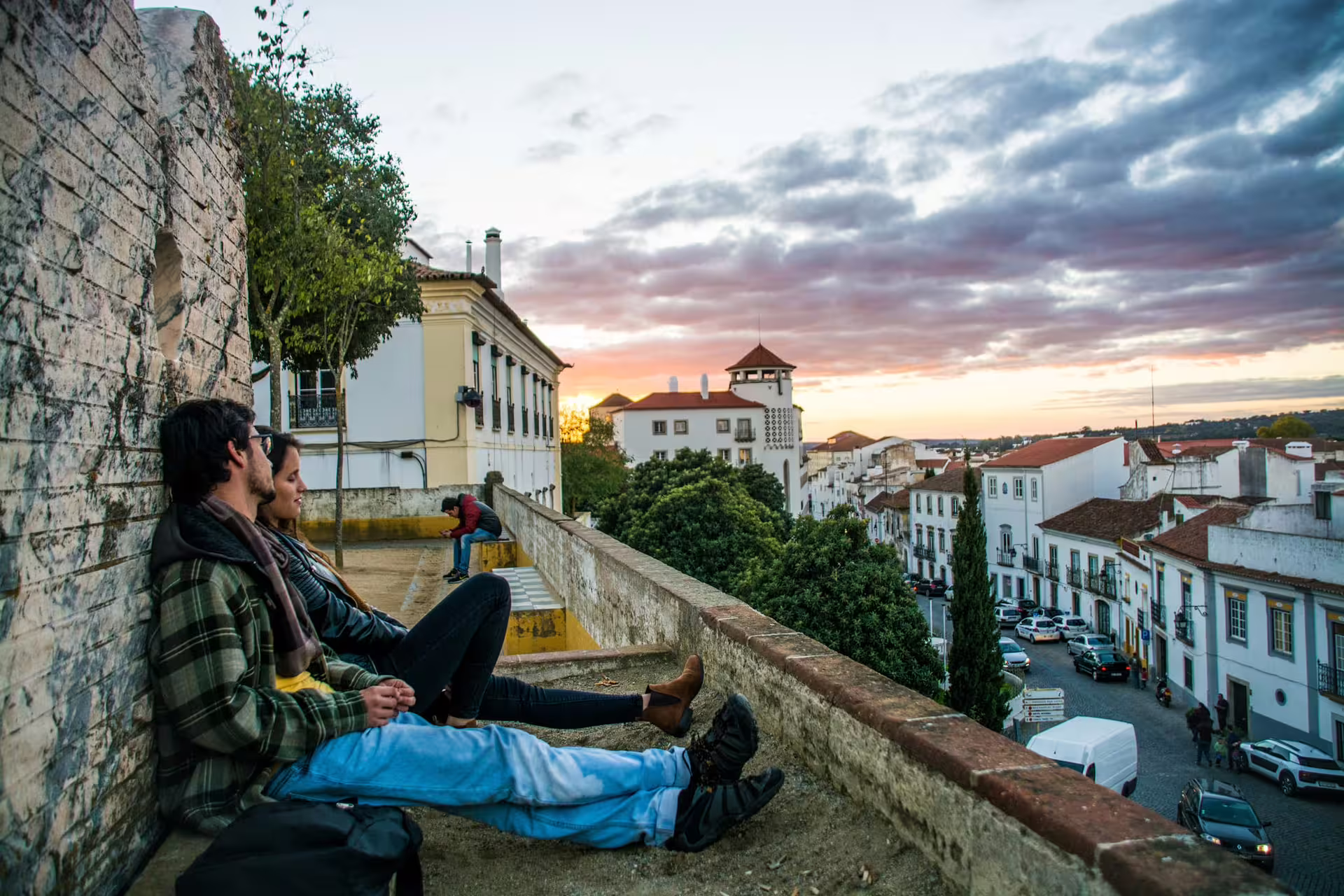 Couple enjoying a sunset view over the historic cityscape of Évora, highlighting the charm of this Portuguese destination.